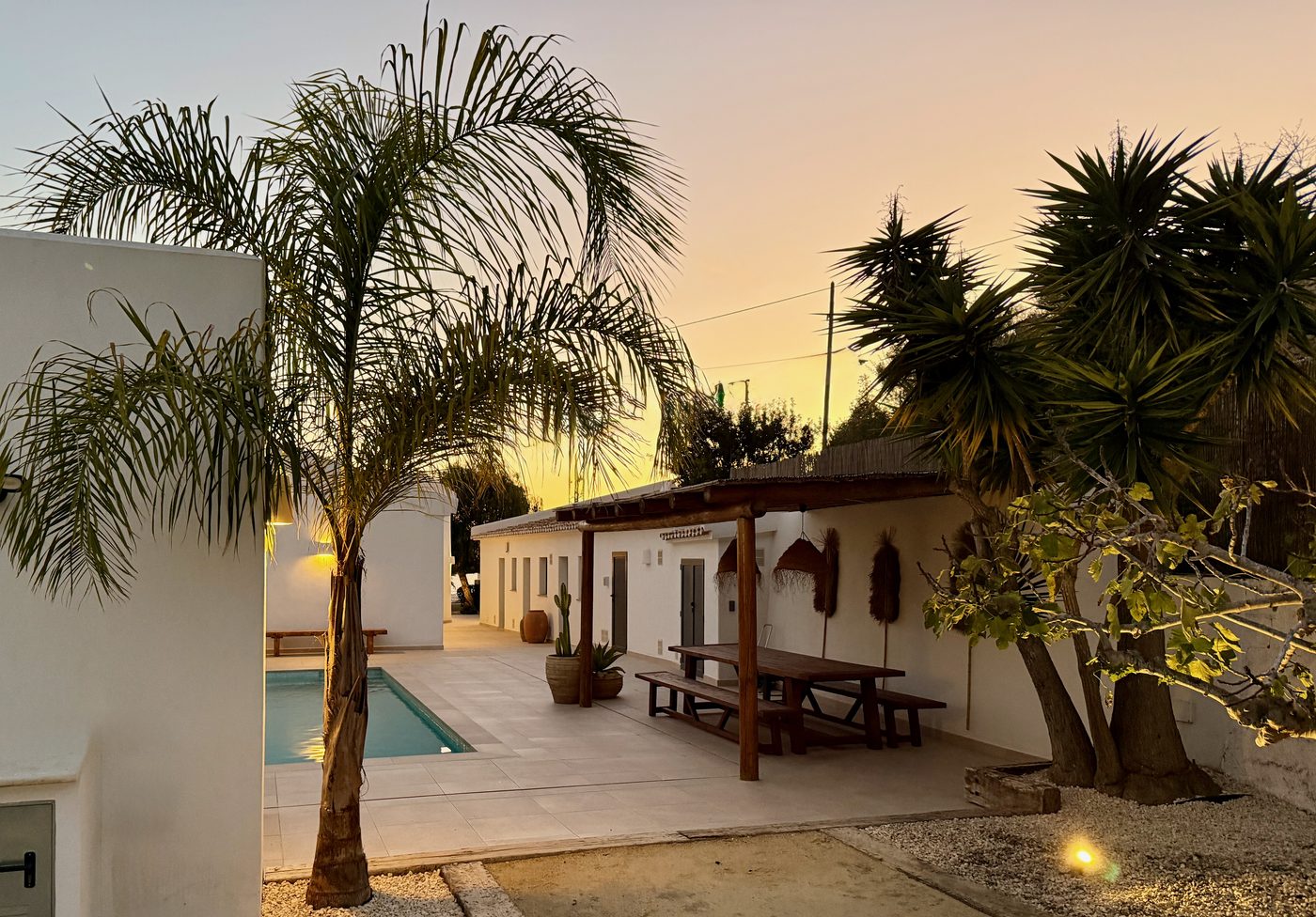 Pool area at sunset with palm trees and golden sky